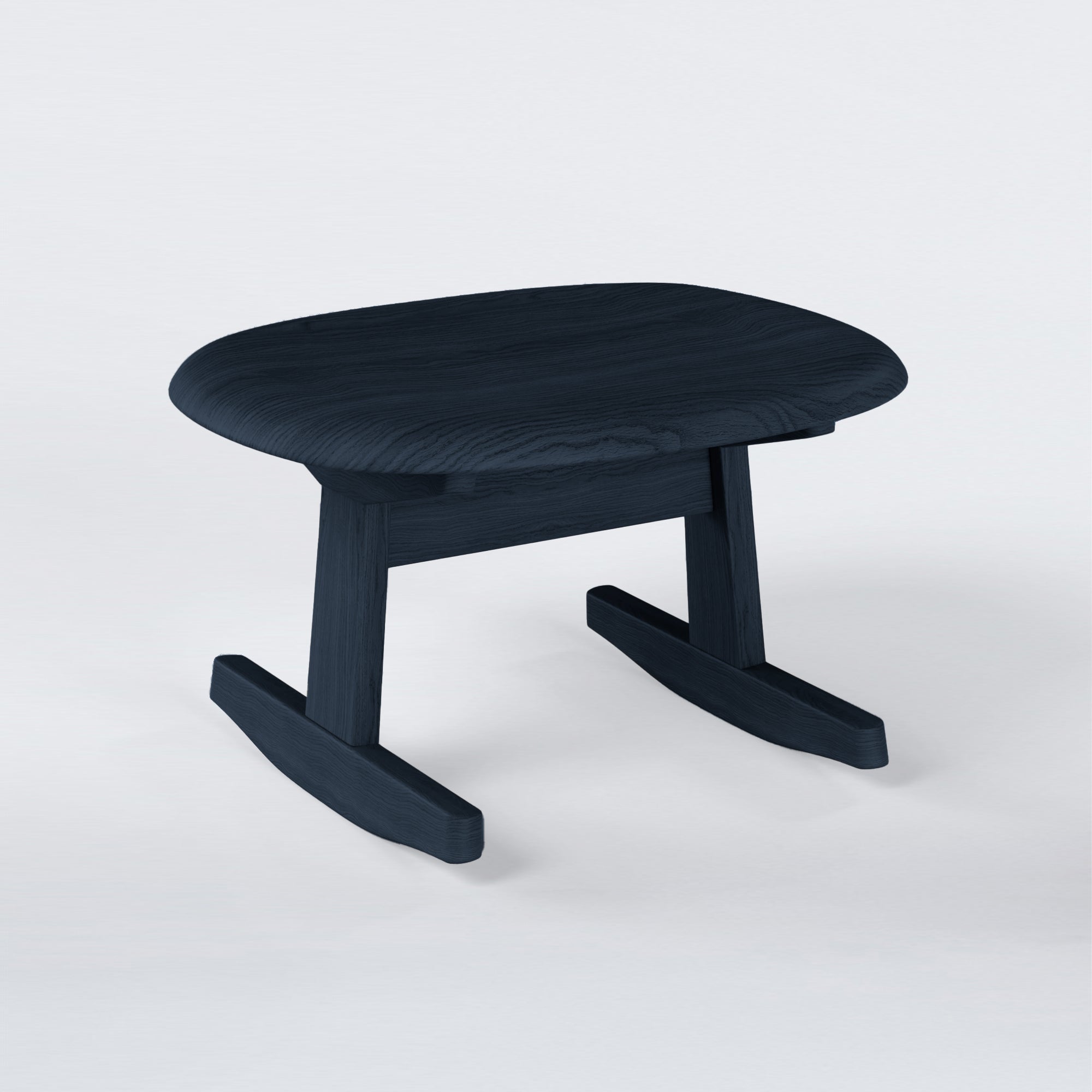 KufenKarl Rocking Ottoman in black-blue stained oak – bold and modern, a striking statement piece.