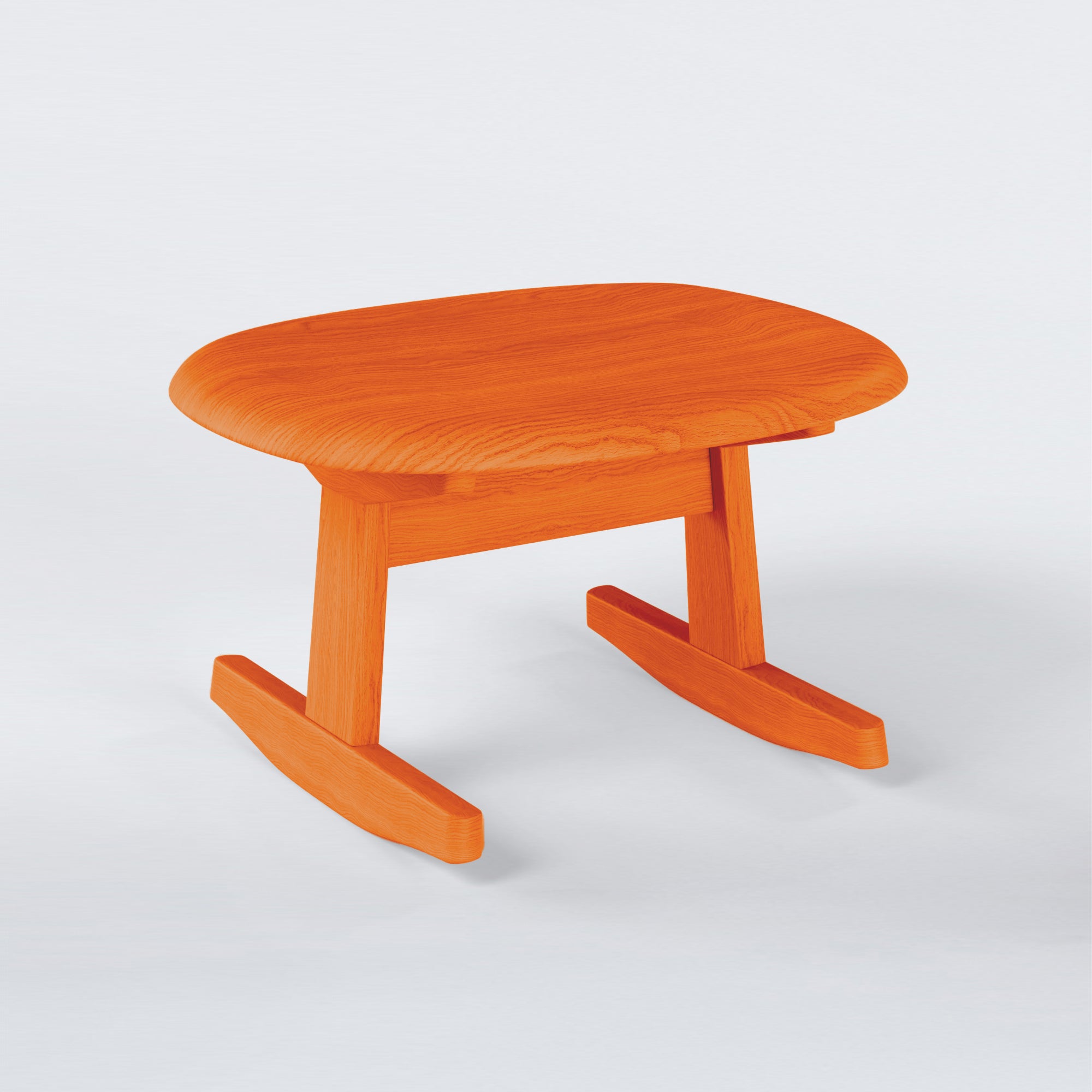 KufenKarl Rocking Ottoman in orange stained oak – warm and sculptural, making a bold statement.