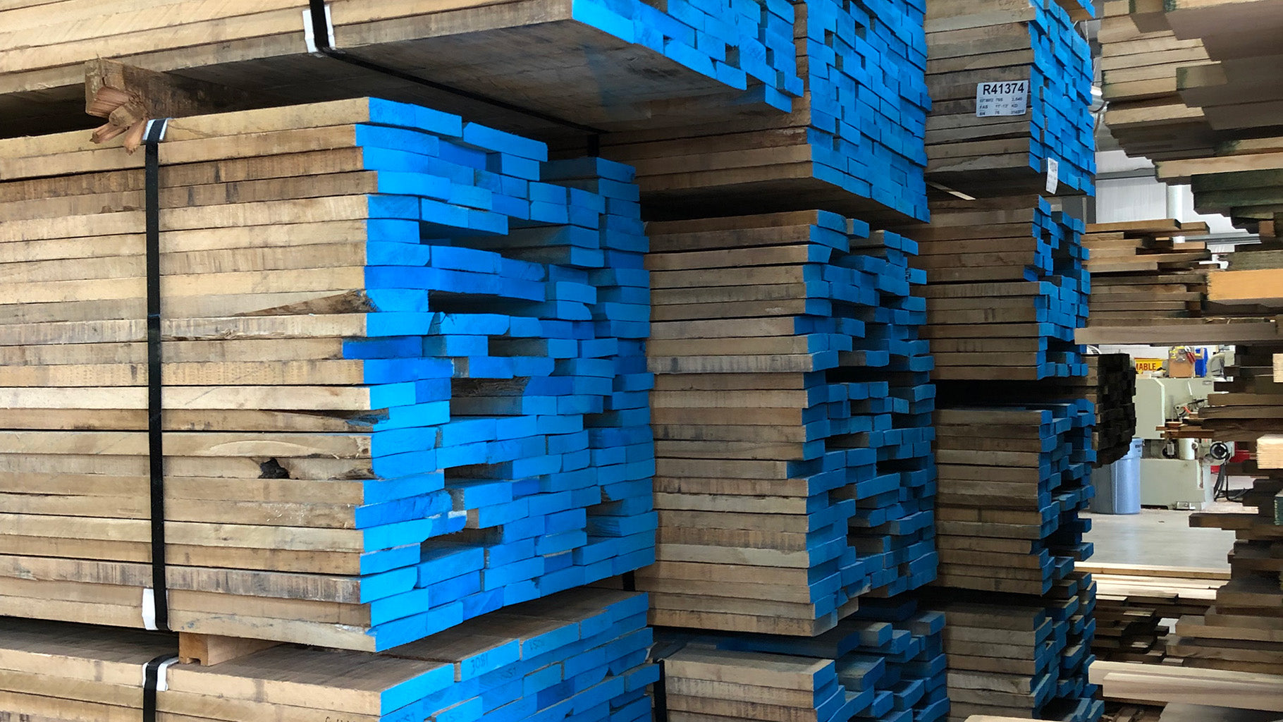 raw walnut, stacked, in workshop, emphasizing sustainable craftsmanship.